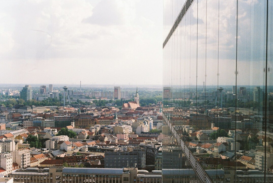 Modern office interior with glass walls overlooking a European city skyline